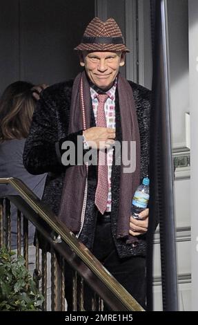 Schauspieler John Malkovich raucht eine Zigarette, während er am Drehort „Red 2" in London, Großbritannien, teilnimmt. 12. November 2012 Stockfoto