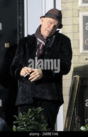 Schauspieler John Malkovich raucht eine Zigarette, während er am Drehort „Red 2" in London, Großbritannien, teilnimmt. 12. November 2012 Stockfoto