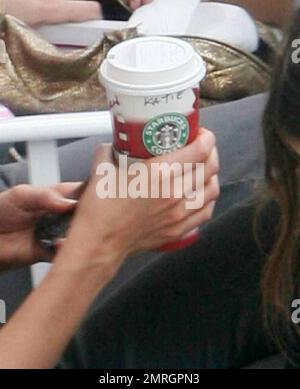 Die Schauspielerin Katie Holmes schreibt mit einem Kaffee in der Hand auf der Promenade von Allure of the Seas während einer Pause von ihrem neuen Film „Jack and Jill“ mit Adam Sandler. Holmes wurde von der Tochter Suri begleitet, die mit anderen Kindern rumhing und später mom dazu brachte, ihre langen Haare aufzurichten. Szenen für „Jack und Jill“ werden an Bord des neuen Schiffs Allure of the Seas von Royal Caribbean gefilmt. Das Schiff ist heute das größte Kreuzfahrtschiff der Welt und die Dreharbeiten finden während der Presseeinführung statt. Fort Lauderdale, Florida 11/21/10. Stockfoto