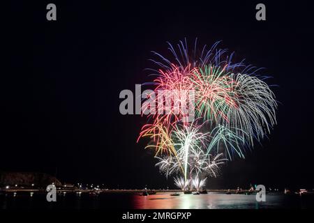 Ein malerischer Blick auf farbenfrohe Feuerwerksproben über dem Hafen von Queen Anne's Battery bei Nacht Stockfoto