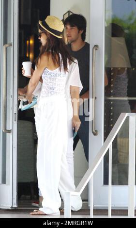 Die Schauspielerin Katie Holmes nimmt einen Kaffee mit, während sie und zwei Begleiter einen Besuch in einem Luxushotel abstatten. Während des kurzen Besuchs spazierte Katie und schaute sich vor der Abreise um das Anwesen. Sie ist in der Stadt und besucht Ehemann Tom Cruise, der gerade seinen neuen Film „Rock of Ages“ in der Gegend filmt. Miami Beach, Florida 6/22/11. Stockfoto