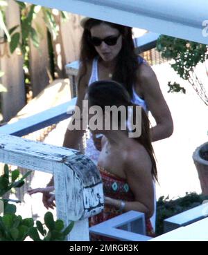 Die Schauspielerin Katie Holmes nimmt einen Kaffee mit, während sie und zwei Begleiter einen Besuch in einem Luxushotel abstatten. Während des kurzen Besuchs spazierte Katie und schaute sich vor der Abreise um das Anwesen. Sie ist in der Stadt und besucht Ehemann Tom Cruise, der gerade seinen neuen Film „Rock of Ages“ in der Gegend filmt. Miami Beach, Florida 6/22/11. Stockfoto