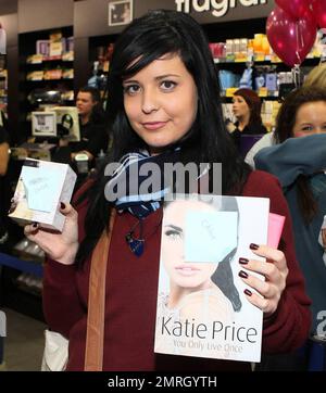 Katie Price (alias Jordan) signiert Autogramme und posiert bei einem Fototermin im Forestside Shopping Centre in Belfast für Fotografen, um ihr neues Parfüm Precious Love zu bewerben. Katie trug eine weißes Weste mit passenden Stiefeln und schien nicht zu bemerken, dass ihre True Religion Jeans geöffnet waren. Belfast, Nordirland. 11/18/10. Stockfoto