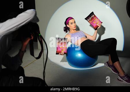 Katy Perry dreht eine neue Werbekampagne für Popchips. Perry wurde am Mittwoch als das neue Gesicht der gesunden Snackmarke enthüllt und fotografiert, auf dem sie ihren fit Körper in Trainingsausrüstung und passgenaue Kleider zeigt. Perry „hob“ zwei Beutel Chips, während er einen lila Sport-BH mit Punktmuster trug und auf einem Workout-Ball entspannte. Die Überschrift der Werbung lautet „Love. Ohne die Griffe. Ich kratze Popchips direkt auf meine Lippen. Gut, dass sie nicht direkt zu meinen Hüften gehen." Eine andere Anzeige zeigt, wie Perry zwei Taschen über der Hörtruhe versteckt und sagt: "Nichts Falsches an ihnen." Ich mag keine Schwindler. Gut, dass da nichts ist Stockfoto