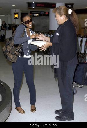 Exklusiv!! Kelly Rowland, amerikanische Sängerin/Songwriterin und Gründungsmitglied von Destiny's Child, trifft am Miami International Airport ein. Nach einem langen Flug wartet sie geduldig auf ihr Gepäck und wird nach einer kurzen Reise zur Gepäckdienstabteilung, um einen verlorenen Koffer zu melden, mit all ihren Sachen wieder vereint. Miami, Florida 10/20/09. Stockfoto