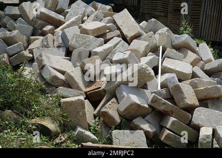 Ein Stapel weißer Ziegel, gestapelt und auf dem Boden auf einer Baustelle gelegen Stockfoto