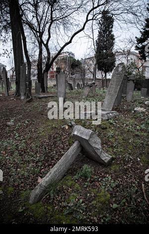 Ein seitlicher Grabstein wurde komplett verlagert und gestürzt, mit verformten Grabsteinen. Man sieht, dass der 400 Jahre alte historische Friedhof in Kadikoy vernachlässigt wird. Der Ayrilik Cesme-Friedhof, der letzte Teil des Karacaahmet-Friedhofs in Istanbul Uskudar, beherbergt die Gräber der Namen, die im Osmanischen Palast gedient haben, und ist in Ruinen verwandelt. Es ist bekannt, dass der Beerdigungsprozess auf dem Friedhof, wo die ersten Beerdigungen vor 400 Jahren stattfanden, bis zum Anfang des 20. Jahrhunderts andauerte. Auf dem Friedhof, wo die meisten Grabsteine zerstört wurden, fielen einige der Köpfe ab, an Stockfoto