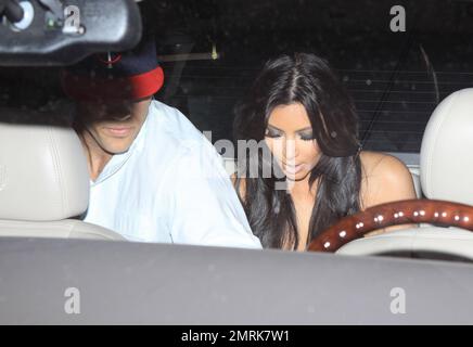 Kim Kardashian trägt ein eng anliegendes, geometrisch gemustertes Kleid, wenn sie das Abendessen im Zuma Miami mit ihrem Freund Kris Humphries und dem Publizisten Jonathan Cheban verlässt. Miami, Florida 5/13/11. Stockfoto