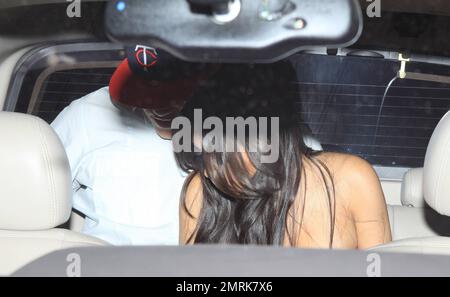 Kim Kardashian trägt ein eng anliegendes, geometrisch gemustertes Kleid, wenn sie das Abendessen im Zuma Miami mit ihrem Freund Kris Humphries und dem Publizisten Jonathan Cheban verlässt. Miami, Florida 5/13/11. Stockfoto