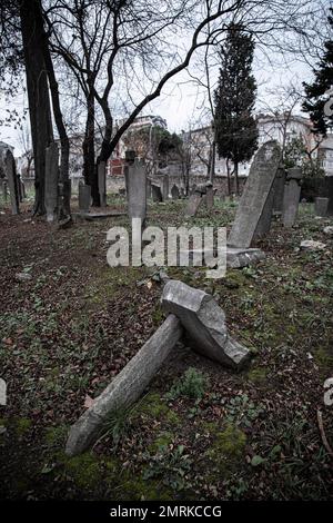 Ein seitlicher Grabstein wurde komplett verlagert und gestürzt, mit verformten Grabsteinen. Man sieht, dass der 400 Jahre alte historische Friedhof in Kadikoy vernachlässigt wird. Der Ayrilik Cesme-Friedhof, der letzte Teil des Karacaahmet-Friedhofs in Istanbul Uskudar, beherbergt die Gräber der Namen, die im Osmanischen Palast gedient haben, und ist in Ruinen verwandelt. Es ist bekannt, dass der Beerdigungsprozess auf dem Friedhof, wo die ersten Beerdigungen vor 400 Jahren stattfanden, bis zum Anfang des 20. Jahrhunderts andauerte. Auf dem Friedhof, wo die meisten Grabsteine zerstört wurden, fielen einige der Köpfe ab, an Stockfoto