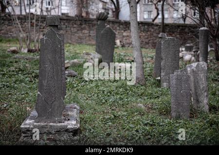 Einige Grabsteine haben Motive. Man sieht, dass der 400 Jahre alte historische Friedhof in Kadikoy vernachlässigt wird. Der Ayrilik Cesme-Friedhof, der letzte Teil des Karacaahmet-Friedhofs in Istanbul Uskudar, beherbergt die Gräber der Namen, die im Osmanischen Palast gedient haben, und ist in Ruinen verwandelt. Es ist bekannt, dass der Beerdigungsprozess auf dem Friedhof, wo die ersten Beerdigungen vor 400 Jahren stattfanden, bis zum Anfang des 20. Jahrhunderts andauerte. Auf dem Friedhof, wo die meisten Grabsteine zerstört wurden, fielen einige der Köpfe ab, und an einigen Orten wurden die Steine mit Farbe gepflanzt Stockfoto