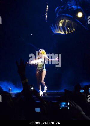 Lady Gaga tritt mit ihren Ersatztänzern auf und zeigt während ihres ausverkauften Konzerts im TD Garden einige dramatische Bühnendarbietungen. Mit vielen Kostümwechseln, darunter ihr funkenmaschineller Bikini, ein schwarzer BH und schwarze Nylonstrümpfe, ein Latex-Bauchteil und ein Maxi-Rock, der ihr aufwendiges Rücken-Tattoo zeigte, Und Accessoires wie eine Peitsche und rote Farbe, um Blut zu simulieren, begeisterte die augenbrauen aufziehende Gaga die gepackte Menge, die man sehen konnte, wie sie auf den Tribünen stand und ihre Hände klatschten. Irgendwann schlüpfte Gaga auch auf der Bühne herum, in die Arme eines Riesen gewickelt Stockfoto