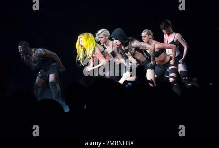 Lady Gaga tritt mit ihren Ersatztänzern auf und zeigt während ihres ausverkauften Konzerts im TD Garden einige dramatische Bühnendarbietungen. Mit vielen Kostümwechseln, darunter ihr funkenmaschineller Bikini, ein schwarzer BH und schwarze Nylonstrümpfe, ein Latex-Bauchteil und ein Maxi-Rock, der ihr aufwendiges Rücken-Tattoo zeigte, Und Accessoires wie eine Peitsche und rote Farbe, um Blut zu simulieren, begeisterte die augenbrauen aufziehende Gaga die gepackte Menge, die man sehen konnte, wie sie auf den Tribünen stand und ihre Hände klatschten. Irgendwann schlüpfte Gaga auch auf der Bühne herum, in die Arme eines Riesen gewickelt Stockfoto