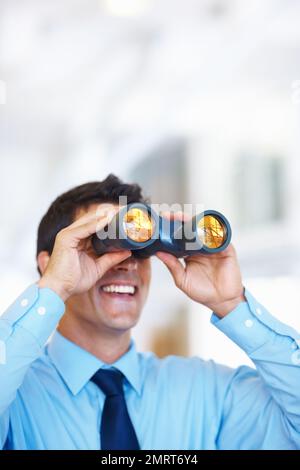 Business-Taktiker. Porträt eines attraktiven jungen Geschäftsmannes mit Fernglas. Stockfoto