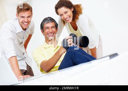 Lächelnde Fotografen. Porträt von drei lächelnden professionellen Fotografen. Stockfoto