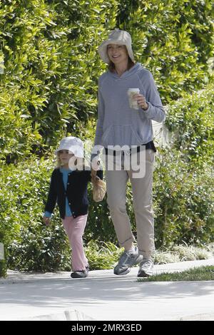 Schauspielerin Marcia Cross geht mit ihrer Tochter spazieren und genießt die Sonntagssonnensonne. Cross trug einen trendigen gestreiften Pullover, rollte Khakis hoch und sie und ihre Tochter trugen passende Hüte. Nachdem sie sich einen Kaffee in ihren Turnschuhen geholt hatte, zog sich Cross später in ihre Sandalen um und trug einen einfachen Designer-Stoff und eine Ledertasche Cline. Cross ist die Mutter zweier süßer Zwillingstochter Eden und Savannah. Los Angeles, Kalifornien. 03/13/11. Stockfoto