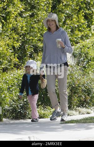 Schauspielerin Marcia Cross geht mit ihrer Tochter spazieren und genießt die Sonntagssonnensonne. Cross trug einen trendigen gestreiften Pullover, rollte Khakis hoch und sie und ihre Tochter trugen passende Hüte. Nachdem sie sich einen Kaffee in ihren Turnschuhen geholt hatte, zog sich Cross später in ihre Sandalen um und trug einen einfachen Designer-Stoff und eine Ledertasche CŽline. Cross ist die Mutter zweier süßer Zwillingstochter Eden und Savannah. Los Angeles, Kalifornien. 03/13/11. Stockfoto