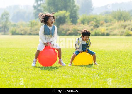 Die beiden Kinder, die auf dem Rasen spielen Stockfoto