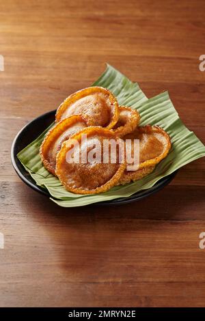 Kue Cucur, der Name eines traditionellen Kuchen aus Jakarta, Indonesien. Serviert auf einem Teller mit Bananenblättern Stockfoto