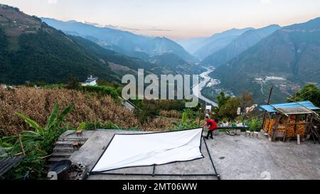 Lushui, Chinas Provinz Yunnan. 21. Okt. 2022. Yang Mingjin richtet im Dorf Denggeng in der autonomen Präfektur Lisu in Nujiang, Provinz Yunnan im Südwesten Chinas, am 21. Oktober 2022 eine Leinwand ein. ZUM Beispiel „Profil: Reifenhändler beleuchtet die Berge mit Filmen“. Kredit: HU Chao/Xinhua/Alamy Live News Stockfoto