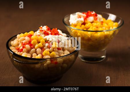 Esquites mit Mais und weißen Kidney Beans, Käse, Mayonnaise und Chili auf dunklem Hintergrund. Mexikanisches Street Food Stockfoto