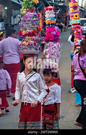 Mon Mädchen in traditioneller Kleidung während der morgendlichen Almosenzeremonie in Sangkhlaburi, Thailand Stockfoto