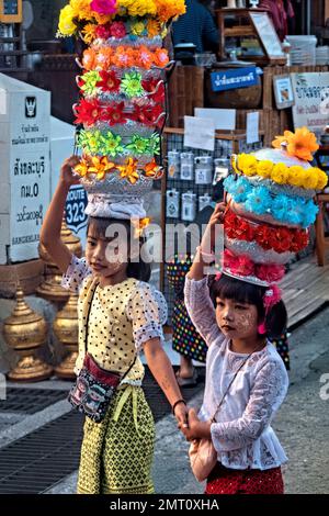 Mon Mädchen in traditioneller Kleidung während der morgendlichen Almosenzeremonie in Sangkhlaburi, Thailand Stockfoto