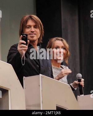 Miley Cyrus und Dad Billy Ray Cyrus machen die Kameras auf die Menge von Fans und Fotografen aufmerksam, während sie die Premiere „Hannah Montana: The Movie“ in London besuchen. 4/23/09. Stockfoto