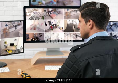 Männlicher Wachmann überwacht Kameras am Arbeitsplatz Stockfoto