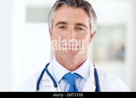 Ihre Gesundheit ist meine Priorität. Porträt eines Arztes, der im Krankenhausgang steht. Stockfoto