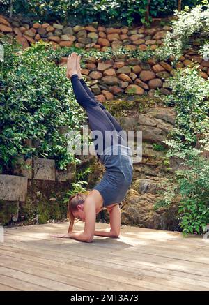 Körper der Göttlichkeit. Eine junge Frau, die draußen Yoga praktiziert. Stockfoto