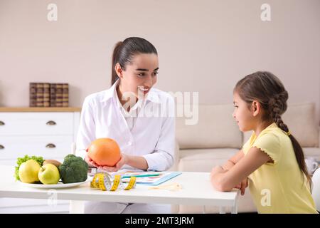 Ein kleines Mädchen, das eine professionelle Ernährungsberaterin im Büro besucht Stockfoto