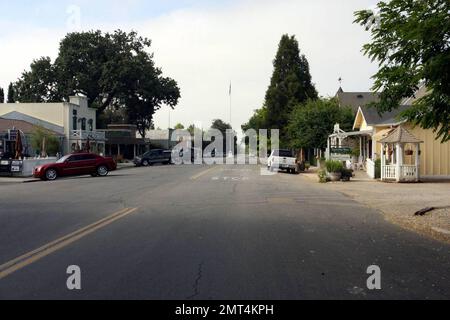 Allgemeiner Blick auf Michael Jacksons ehemalige Residenz, Neverland, und die Gemeinde Los Olivos. Sein ehemaliges Anwesen liegt nördlich von Santa Barbara in der Kleinstadt Los Olivos. Eine lange Fahrt entlang einer kleinen Straße, flankiert von Kuhweiden und Pferdefarmen, führt nach Nimmerland. Es waren auch Medien und eine wachsende Zahl von Fans und Wunschern vertreten, die Blumen und Notizen hinterließen. Die Instandhaltungsteams pflegten das Gelände weiter, während zahlreiche Autos das Anwesen betraten und verließen. Eine Flagge flog auf Halbmast zu Ehren von Michael Jackson, als Sie die verschlafene Stadt Los Olivos betraten, 100 Einwohner Stockfoto