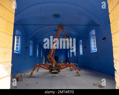 Arbeiter, die von einem Kirschpflücker im Inneren eines der Gebäude der Villa reale di Marlia Capannori Toskana Italien arbeiten Stockfoto