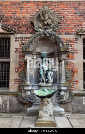 Ein vertikales Bild eines Brunnens im Schloss Frederiksborg, Hilerod, Dänemark. Stockfoto