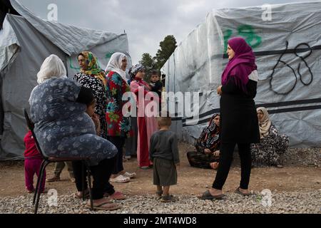 FILE - In this Monday, May 29, 2017 file photo, Syrian women with their children speak, at the refugee camp of Ritsona about 86 kilometers (53 miles) north of Athens. The European Commission announced on Thursday, July 27, 2017 a euro209 million-euro ($243 million) package includes a 151 million-euro program to help refugee families rent accommodation in Greek cities and provide them with money in an effort to help them move out of refugee camps. (AP Photo/Petros Giannakouris, File)
