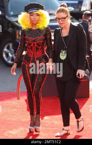 Der Sänger Nicki Minaj trägt einen schwarz gemusterten Unitard mit schwarzer Mütze, hohen Absätzen mit schwarzen Spikes und einer leuchtend gelben Perücke und wird bei den MTV Video Music Awards 2012 im Staples Center in Los Angeles, Kalifornien, ausgezeichnet. 6. September 2012 Stockfoto
