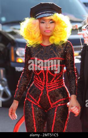 Der Sänger Nicki Minaj trägt einen schwarz gemusterten Unitard mit schwarzer Mütze, hohen Absätzen mit schwarzen Spikes und einer leuchtend gelben Perücke und wird bei den MTV Video Music Awards 2012 im Staples Center in Los Angeles, Kalifornien, ausgezeichnet. 6. September 2012 Stockfoto