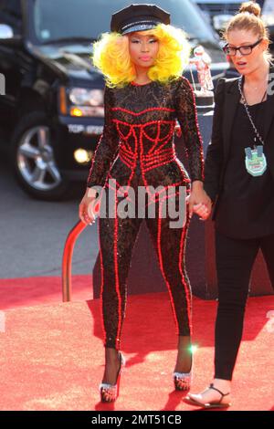 Der Sänger Nicki Minaj trägt einen schwarz gemusterten Unitard mit schwarzer Mütze, hohen Absätzen mit schwarzen Spikes und einer leuchtend gelben Perücke und wird bei den MTV Video Music Awards 2012 im Staples Center in Los Angeles, Kalifornien, ausgezeichnet. 6. September 2012 Stockfoto