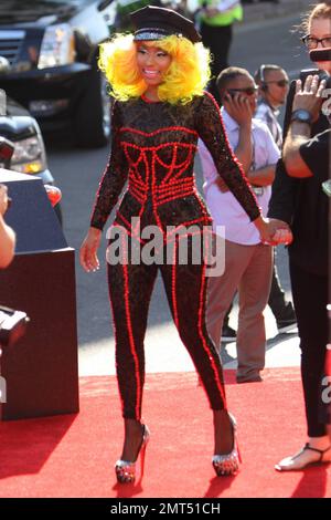 Der Sänger Nicki Minaj trägt einen schwarz gemusterten Unitard mit schwarzer Mütze, hohen Absätzen mit schwarzen Spikes und einer leuchtend gelben Perücke und wird bei den MTV Video Music Awards 2012 im Staples Center in Los Angeles, Kalifornien, ausgezeichnet. 6. September 2012 Stockfoto