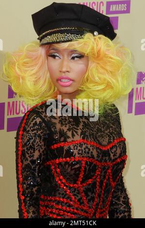 Der Sänger Nicki Minaj trägt einen schwarz gemusterten Unitard mit schwarzer Mütze, hohen Absätzen mit schwarzen Spikes und einer leuchtend gelben Perücke und wird bei den MTV Video Music Awards 2012 im Staples Center in Los Angeles, Kalifornien, ausgezeichnet. 6. September 2012 Stockfoto