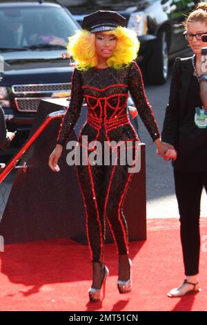 Der Sänger Nicki Minaj trägt einen schwarz gemusterten Unitard mit schwarzer Mütze, hohen Absätzen mit schwarzen Spikes und einer leuchtend gelben Perücke und wird bei den MTV Video Music Awards 2012 im Staples Center in Los Angeles, Kalifornien, ausgezeichnet. 6. September 2012 Stockfoto