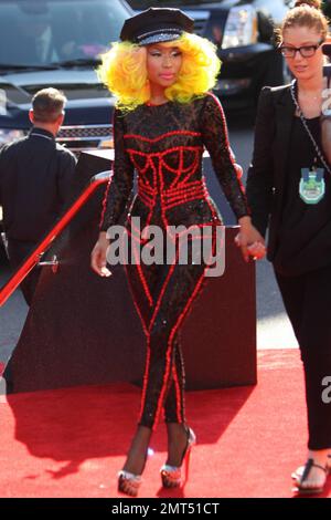 Der Sänger Nicki Minaj trägt einen schwarz gemusterten Unitard mit schwarzer Mütze, hohen Absätzen mit schwarzen Spikes und einer leuchtend gelben Perücke und wird bei den MTV Video Music Awards 2012 im Staples Center in Los Angeles, Kalifornien, ausgezeichnet. 6. September 2012 Stockfoto