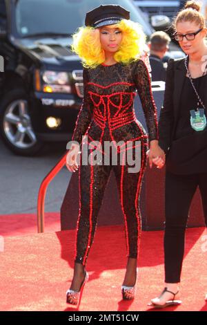 Der Sänger Nicki Minaj trägt einen schwarz gemusterten Unitard mit schwarzer Mütze, hohen Absätzen mit schwarzen Spikes und einer leuchtend gelben Perücke und wird bei den MTV Video Music Awards 2012 im Staples Center in Los Angeles, Kalifornien, ausgezeichnet. 6. September 2012 Stockfoto