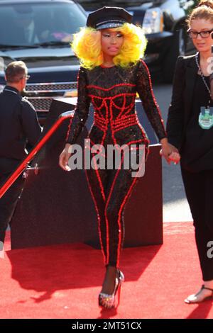 Der Sänger Nicki Minaj trägt einen schwarz gemusterten Unitard mit schwarzer Mütze, hohen Absätzen mit schwarzen Spikes und einer leuchtend gelben Perücke und wird bei den MTV Video Music Awards 2012 im Staples Center in Los Angeles, Kalifornien, ausgezeichnet. 6. September 2012 Stockfoto