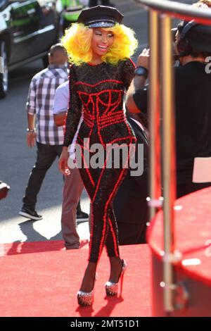 Der Sänger Nicki Minaj trägt einen schwarz gemusterten Unitard mit schwarzer Mütze, hohen Absätzen mit schwarzen Spikes und einer leuchtend gelben Perücke und wird bei den MTV Video Music Awards 2012 im Staples Center in Los Angeles, Kalifornien, ausgezeichnet. 6. September 2012 Stockfoto