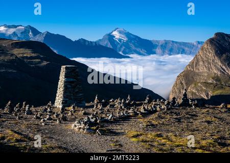 Berge und Hügel der Graianischen Alpen, von Col de L'Iseran aus gesehen 2770 m, der höchste asphaltierte Pass in den Alpen, das Tal voller Nebel. Stockfoto