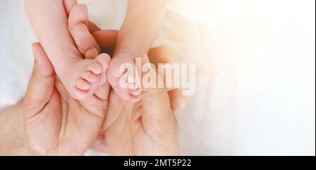 Babyfüße in Vaters Händen. Mein Vater und sein Kind. Happy Family Concept. Wunderschönes konzeptionelles Bild von Vaterschaft Stockfoto