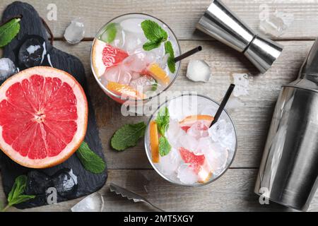 Flach liegend mit Gläsern alkoholischen Cocktails und Barkeeper-Werkzeugen auf Holztisch Stockfoto