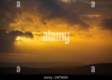 West Yorkshire, Großbritannien. 31. Januar 2023. Wetter in Großbritannien. Ein dramatischer Sonnenuntergang über dem Calder Valley mit einem Silhouetten Stoodley Pike Memorial in der Skyline. Das Calder Valley und die Städte Hebden Bridge und Halifax sind im BBC-Drama Happy Valley mit Sarah Lancashire zu sehen. Kredit: Windmill Images/Alamy Live News Stockfoto